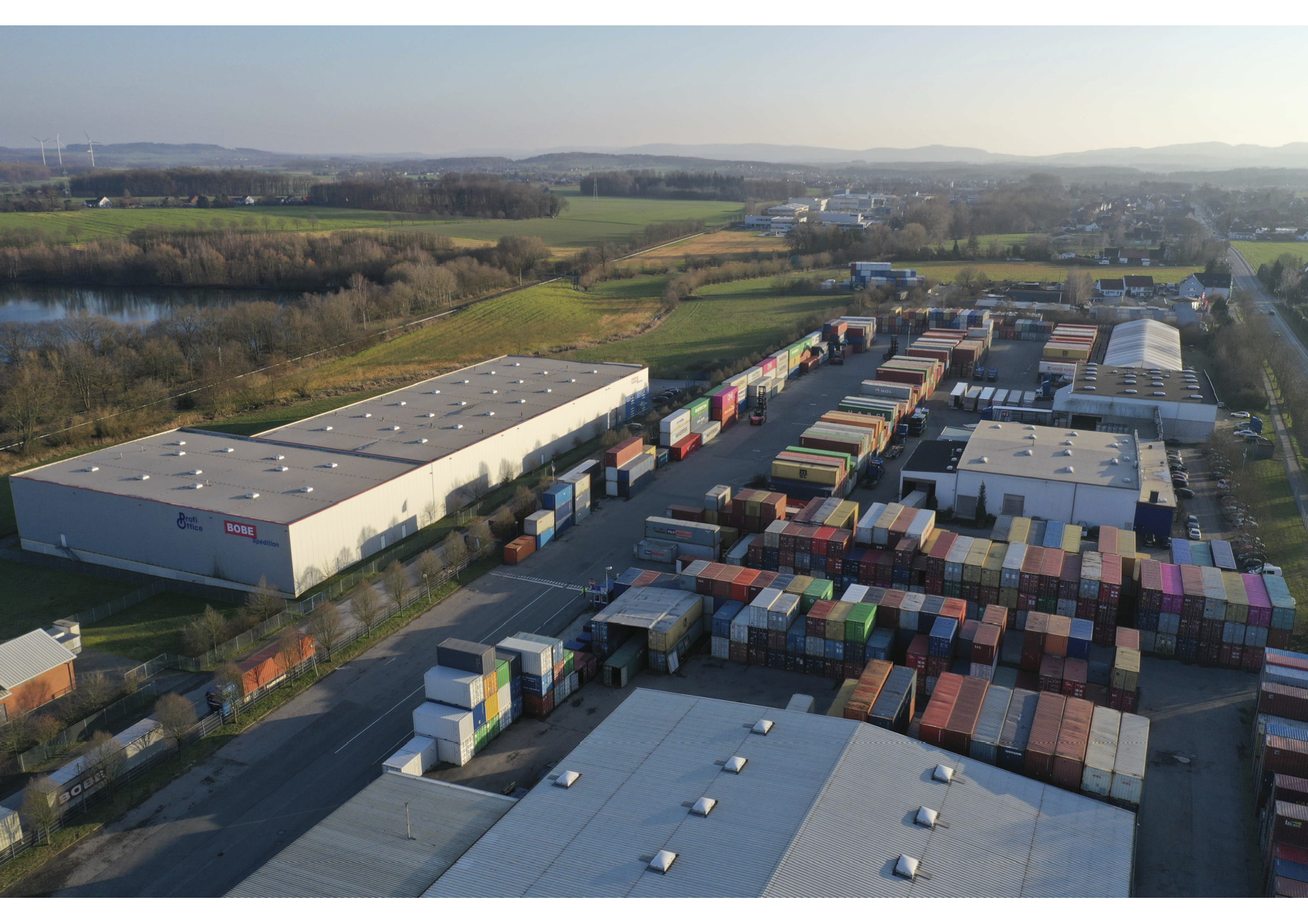 Drohnenansicht des Firmengeländes mit Lagerhallen und Container-Depot in Ostwestfalen
