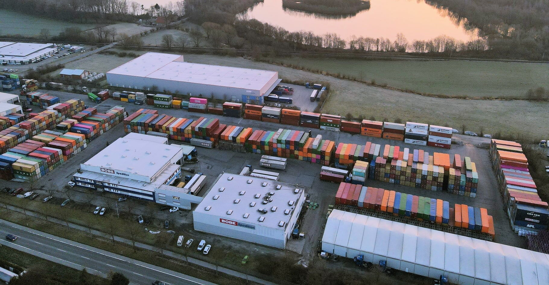 Vogelperspektive auf das Betriebsgelände mit Lagerhallen und Containerdepot – BOBE