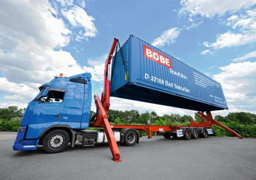 Heckansicht eines BOBE-Spezialaufliegers mit Seitenlader und individuellem Kunden-Branding auf dem Betriebshof – BOBE