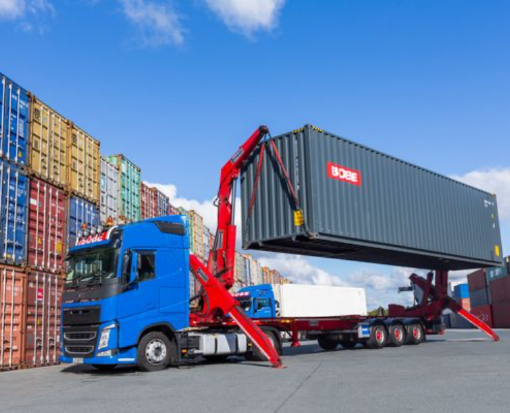 LKW mit Kranarm hebt grauen Seecontainer mit BOBE Logo – BOBE Vermietung
