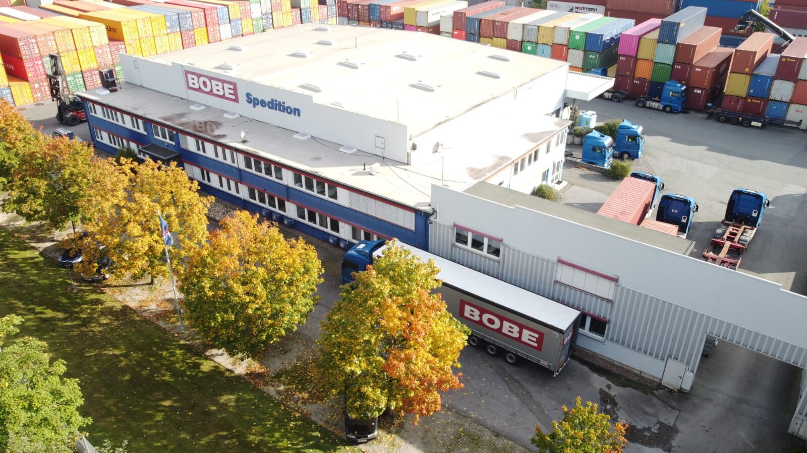 Luftaufnahme des BOBE Firmengeländes mit Bürogebäude, Lagerhalle und angrenzendem Containerlager – BOBE