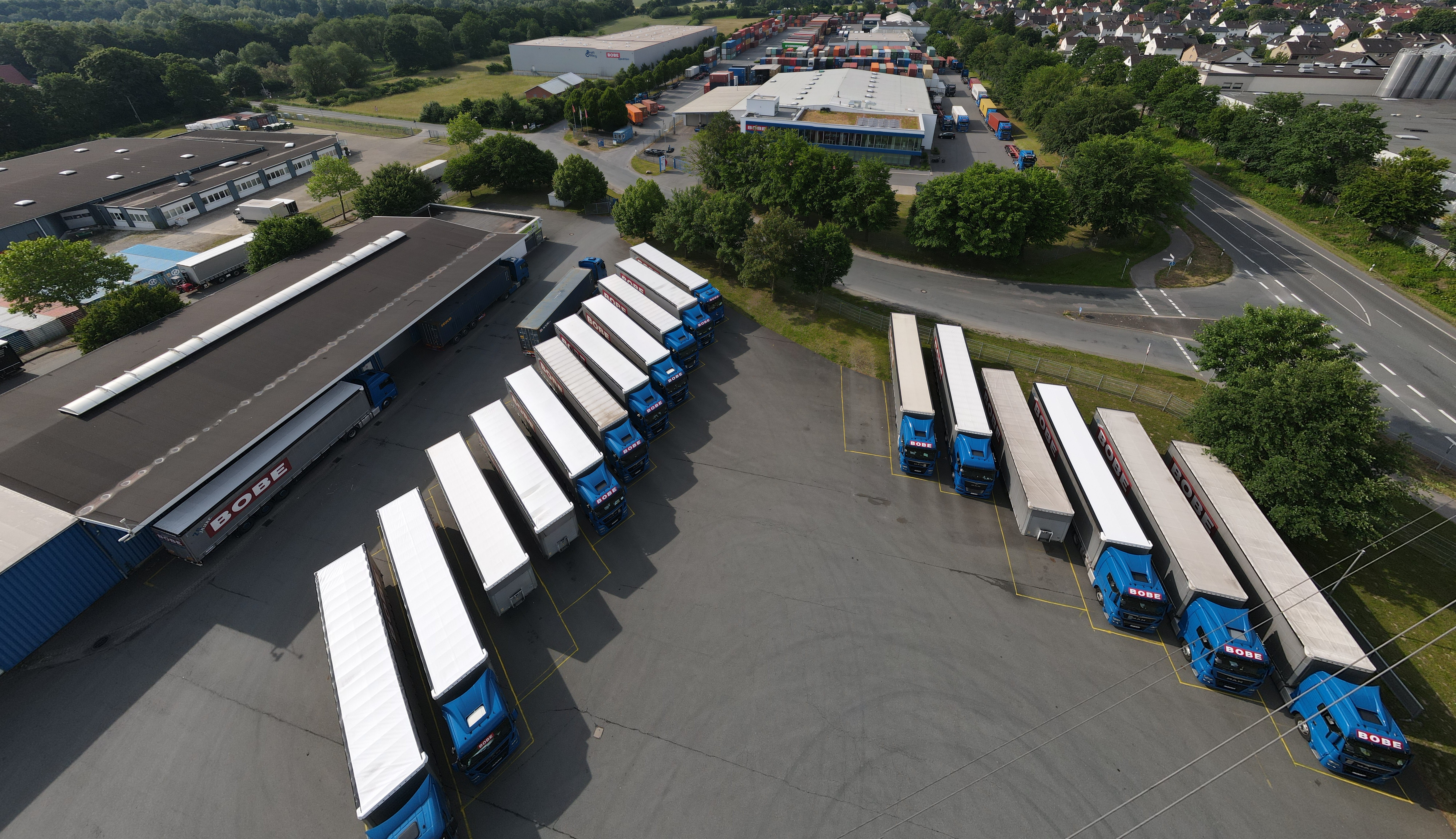 Luftaufnahme des BOBE-Betriebshofes mit zahlreichen geparkten Sattelzügen und angrenzenden Lagerhallen im Industriegebiet – BOBE