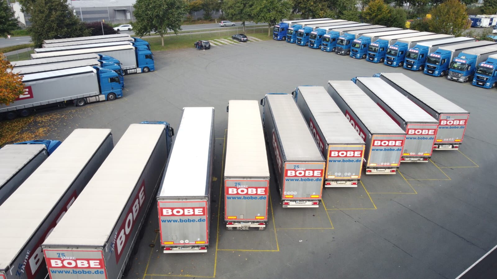 Luftaufnahme zahlreicher BOBE-Sattelzüge, die akkurat aufgereiht auf dem Betriebshof in Bad Salzuflen stehen – BOBE