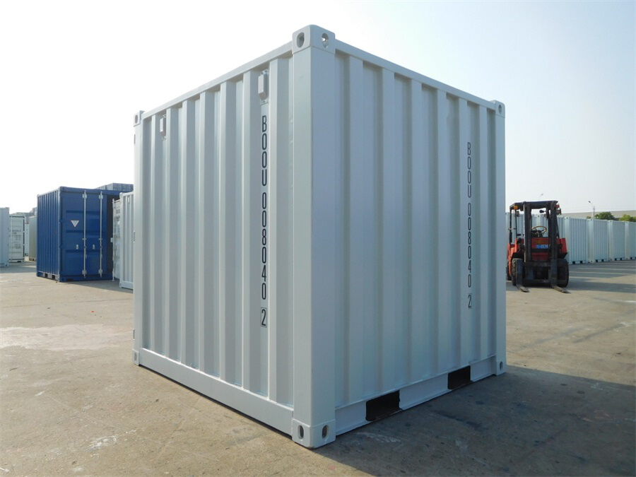 Kompakter weißer Materialcontainer auf einem Betriebshof mit Gabelstapler im Hintergrund