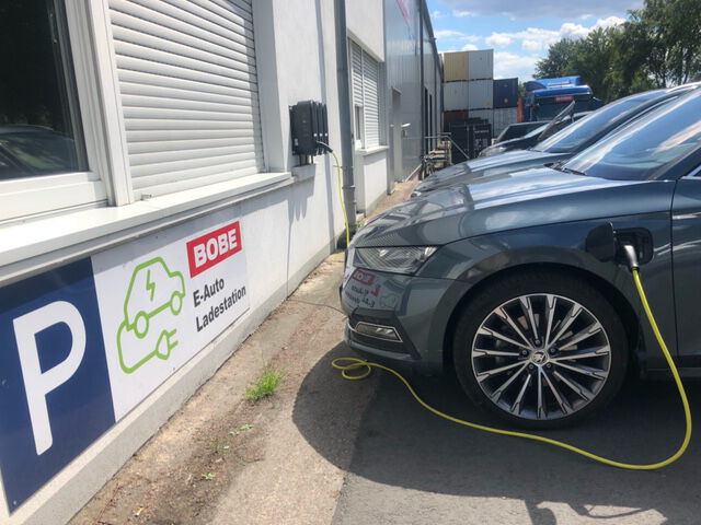 Graues Elektroauto an einer BOBE E-Auto Ladestation mit Hinweisschild – BOBE