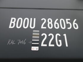 Detailaufnahme einer Containernummer mit RAL-Farbfächer zum Abgleich der Lackierung in Anthrazitgrau