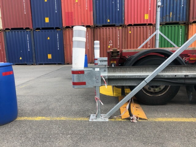 Sicherheitsbegrenzung und Leitplanke vor gestapelten Überseecontainern auf dem Betriebsgelände – BOBE