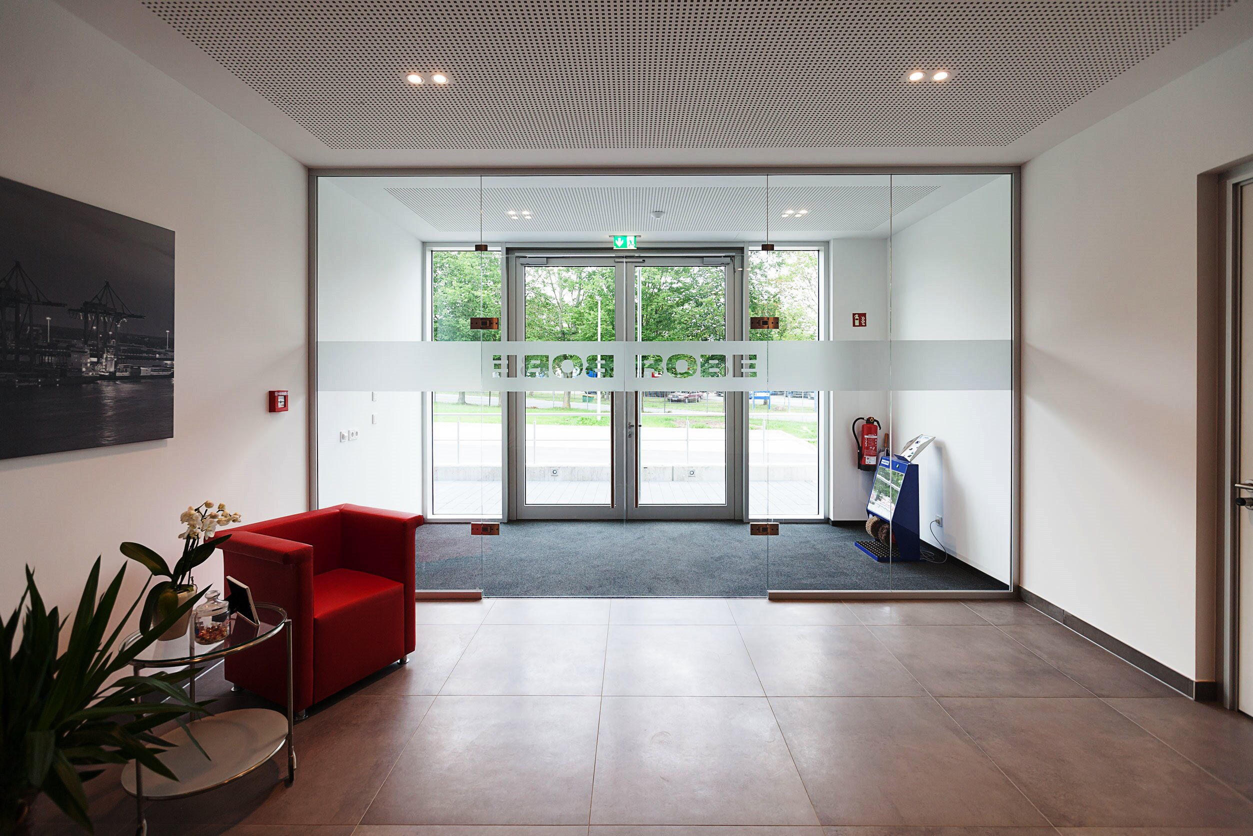 Innenansicht des Empfangsbereichs der BOBE Speditions GmbH mit Blick auf den verglasten Eingangsbereich und das Firmenlogo – BOBE