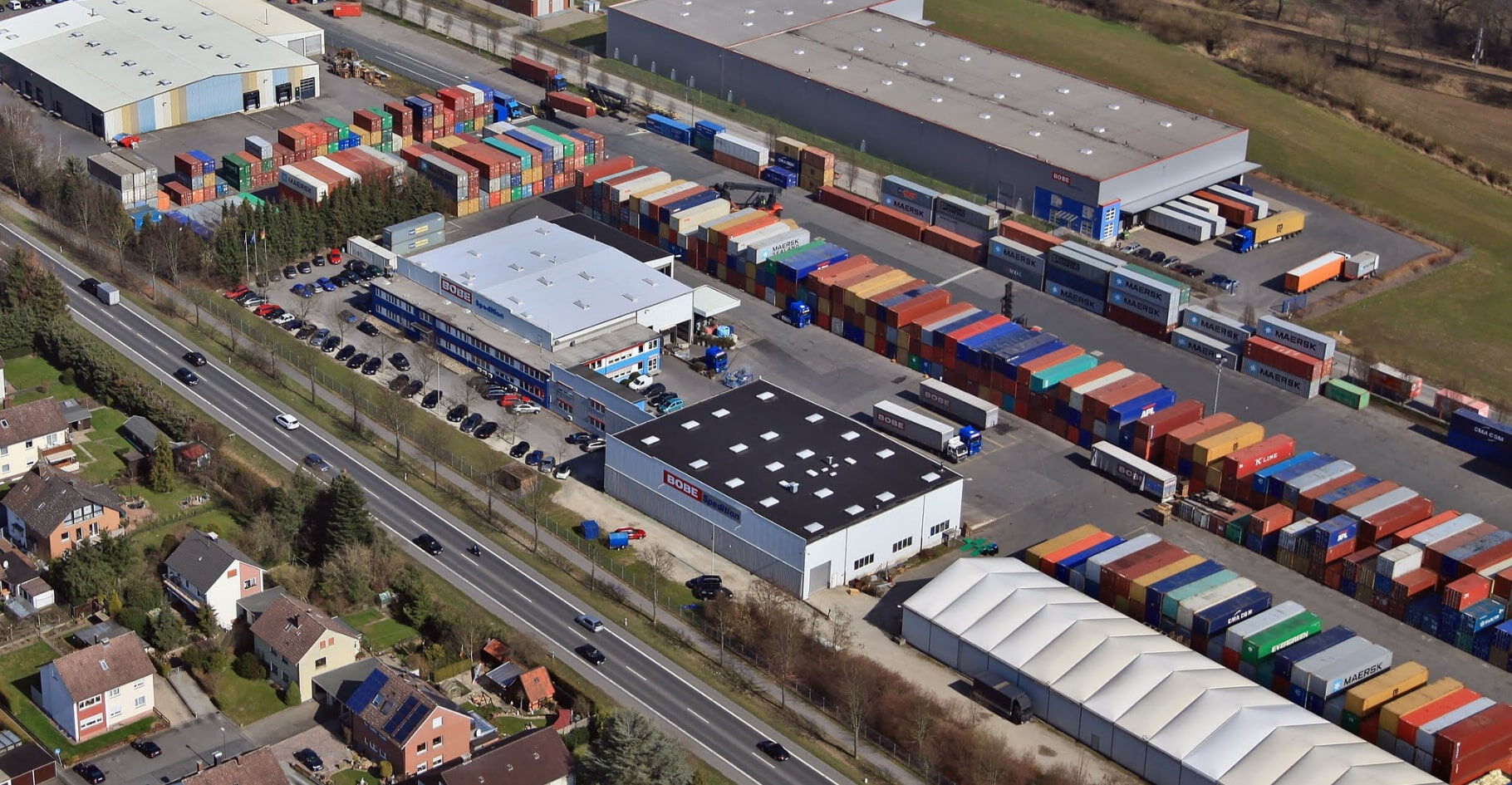 Vogelperspektive auf das Betriebsgelände mit zahlreichen gelagerten Containern – BOBE